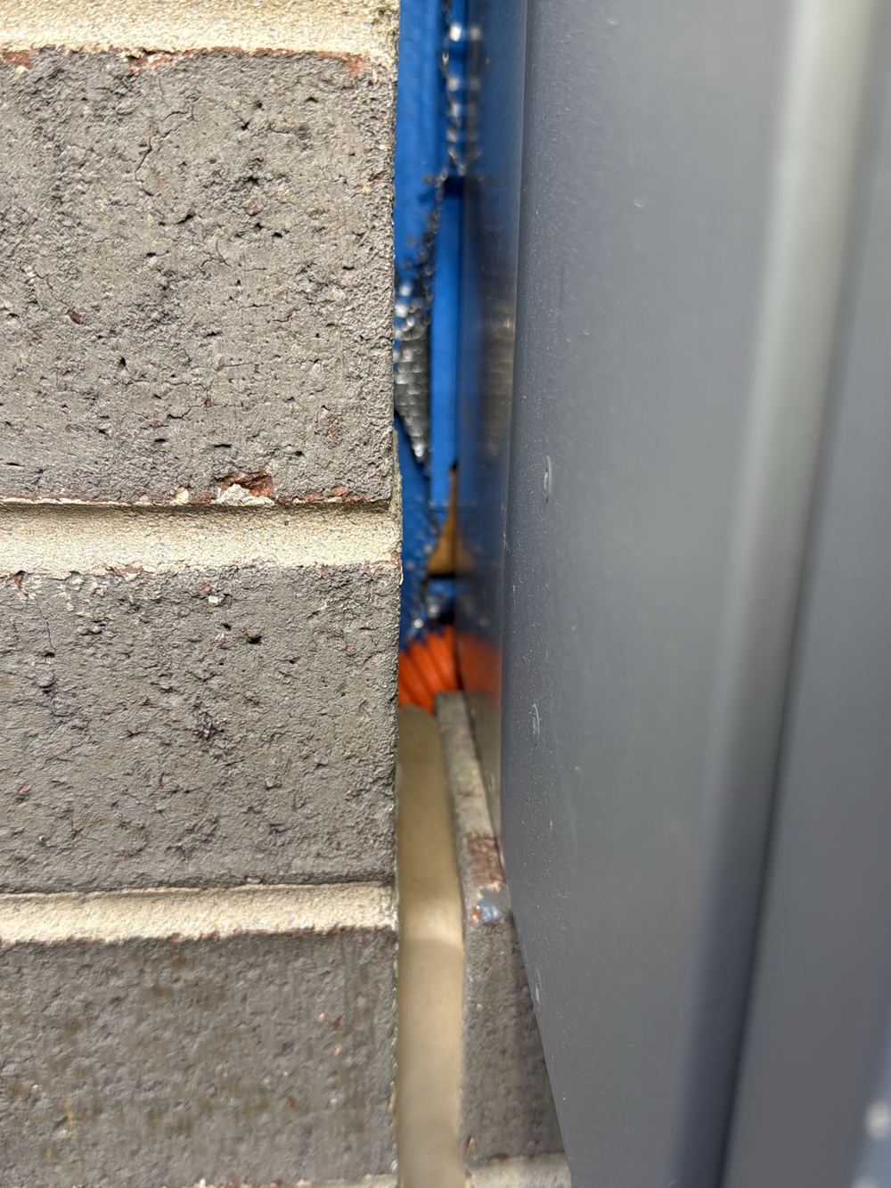 Unsealed edge where the meter box meets the brickwork, open to the wall cavity, found during a pre-handover inspection in Pakenham