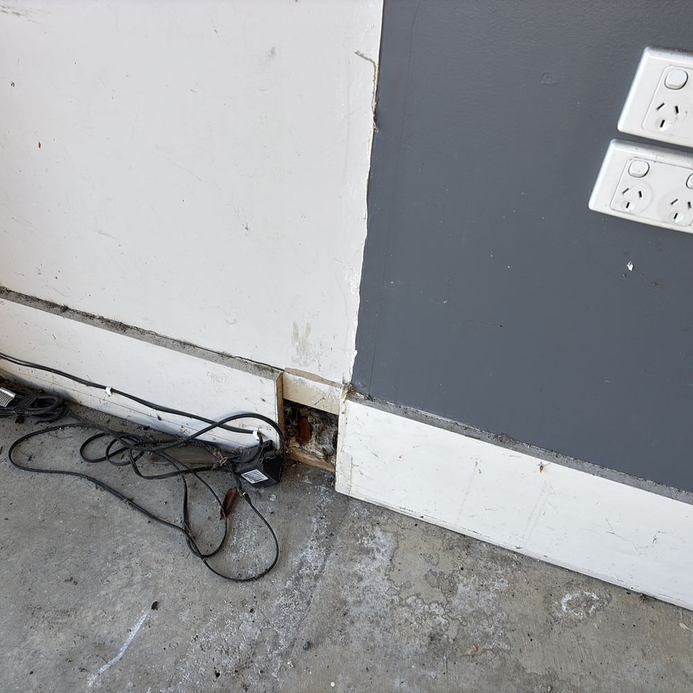 Wall lining broken through at skirting level, well beyond a patch and paint, found during a pre-purchase inspection in Pakenham