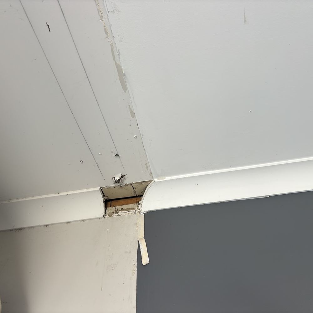 Wall lining broken away at a corner, exposing the frame behind it, found during a pre-purchase inspection in Pakenham